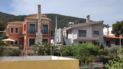 a group of houses with mountains in the background at Serenity Villa-Ground floor-Sea view- sea 150m away in Porto Rafti