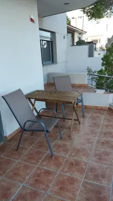 a wooden table and two chairs on a patio at Serenity Villa-Ground floor-Sea view- sea 150m away in Porto Rafti