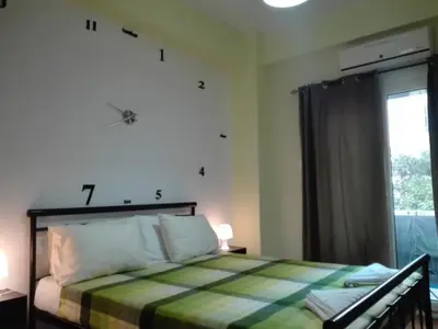 a bedroom with a bed with a checkered blanket at Athens Home 2 in Athens
