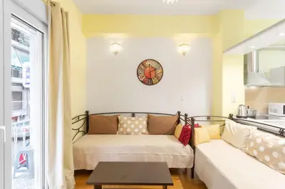 a living room with a couch and a clock on the wall at Athens Home 2 in Athens
