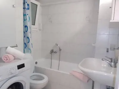 a white bathroom with a toilet and a sink at Athens Home 2 in Athens