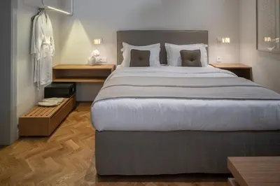 a bedroom with a large bed and wooden floors at COCO-MAT Athens Jumelle in Athens