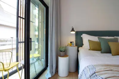 a bedroom with a bed and a balcony at COCO-MAT Athens Jumelle in Athens