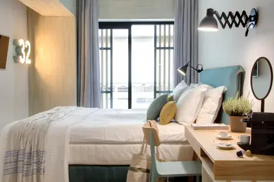 a hotel room with a bed and a desk and a table at COCO-MAT Athens Jumelle in Athens