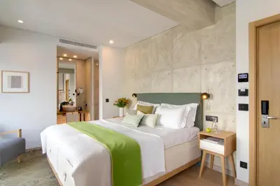 a bedroom with a large bed with a green headboard at COCO-MAT Athens Jumelle in Athens