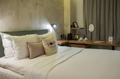 a bedroom with a bed with white sheets and pillows at COCO-MAT Athens Jumelle in Athens