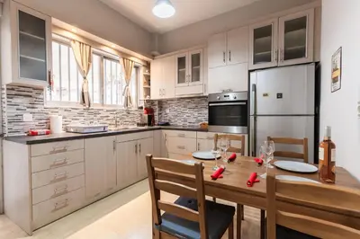 a kitchen with a wooden table and a refrigerator at Alimos Apartment in Athens