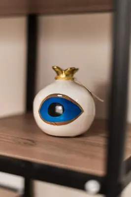 a vase with an eye on top of a table at Alimos Apartment in Athens