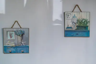 two pictures are hanging on a wall with a shelf at Alimos Apartment in Athens