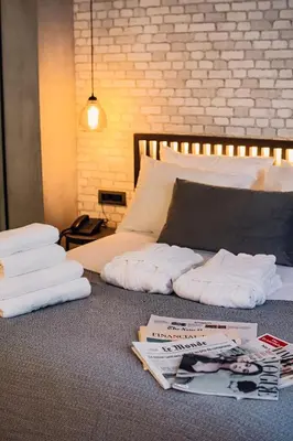 a bed with towels and magazines on top of it at Project 3 Urban Chic Hotel in Athens