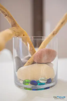 a glass vase filled with rocks and wooden sticks at Chic and Minimal apartment close to Thissio Metro in Athens