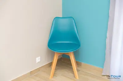 a green chair sitting in a corner of a room at Chic and Minimal apartment close to Thissio Metro in Athens