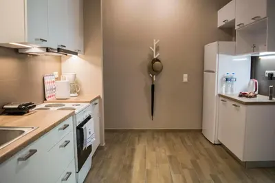 a kitchen with white cabinets and a refrigerator at Chic and Minimal apartment close to Thissio Metro in Athens