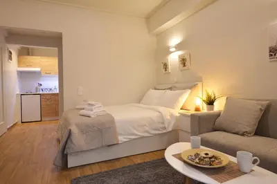 a bedroom with a large bed and a couch at Studio Posh with garden in Kolonaki in Athens
