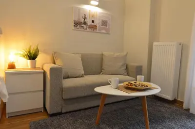 a living room with a couch and a table at Studio Posh with garden in Kolonaki in Athens