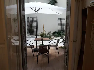 a dining room with a table and chairs and an umbrella at Studio Posh with garden in Kolonaki in Athens