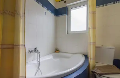 a white tub in a bathroom with a window at Nea Smirni Luxury Apartment in Athens