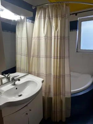 a bathroom with a sink and a shower curtain at Nea Smirni Luxury Apartment in Athens