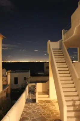 a staircase on the side of a building at night at Blue Dolphin Studios and Apartment in Vaia