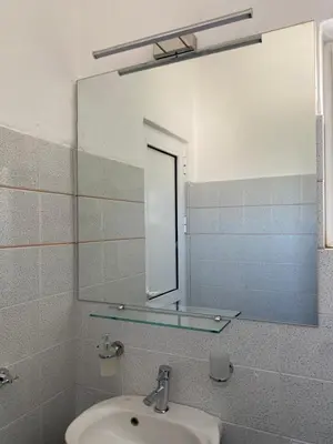 a bathroom with a sink and a mirror at Blue Dolphin Studios and Apartment in Vaia