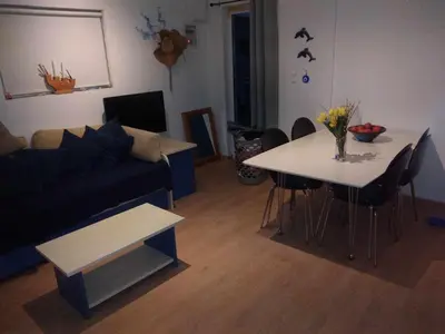 a living room with a couch and a table at Blue Dolphin Studios and Apartment in Vaia