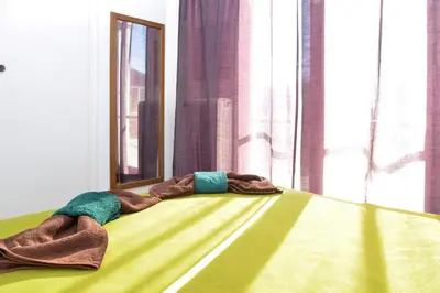 two blankets laying on a bed in front of a window at Acropolis amazing balcony view 3 minutes walking to the museum in Athens