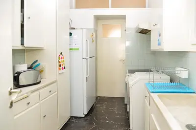 a kitchen with white cabinets and a refrigerator at Acropolis amazing balcony view 3 minutes walking to the museum in Athens