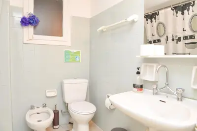 a white bathroom with a toilet and a sink at Acropolis amazing balcony view 3 minutes walking to the museum in Athens