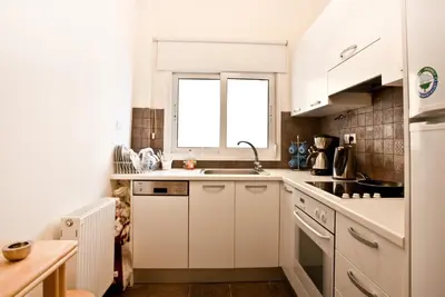 a white kitchen with a sink and a window at Acropolis area 5 minutes to the Museum and metro in Athens