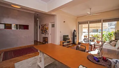 a living room with a table and a couch at 2 BEDROOM APARTMENT AT THE HISTORICAL CENTER, VIEW TO ACROPOLIS in Athens