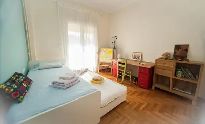 a small bedroom with a bed and a desk at 2 BEDROOM APARTMENT AT THE HISTORICAL CENTER, VIEW TO ACROPOLIS in Athens