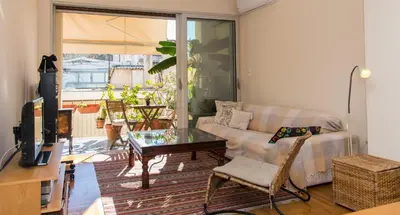 a living room with a couch and a glass table at 2 BEDROOM APARTMENT AT THE HISTORICAL CENTER, VIEW TO ACROPOLIS in Athens