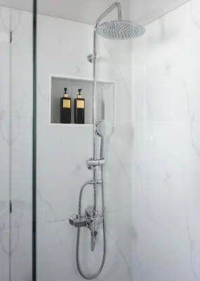 a shower with two bottles on a shelf in a bathroom at Acropolis Sandra Homes in Athens