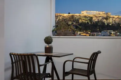 a table and two chairs sitting next to a window at Acropolis Sandra Homes in Athens