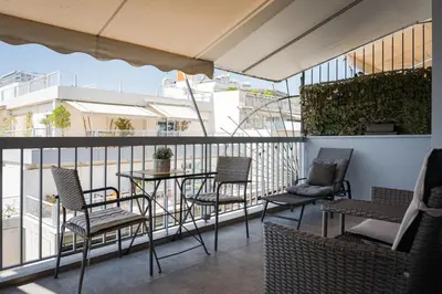 a patio with chairs and a table on a balcony at Acropolis Sandra Homes in Athens