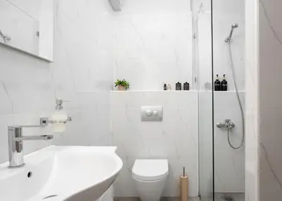 a white bathroom with a toilet and a shower at Acropolis Sandra Homes in Athens