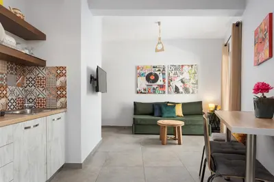 a living room with a green couch and a table at Acropolis Sandra Homes in Athens