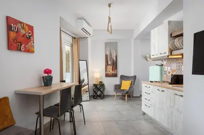 a kitchen with a table and chairs in a room at Acropolis Sandra Homes in Athens