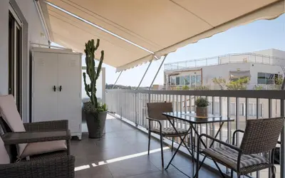 a balcony with a table and chairs and a ship at Acropolis Sandra Homes in Athens