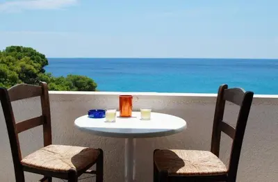 a table and two chairs on a balcony with the ocean at Hotel 3 Adelfia in Agia Marina Aegina