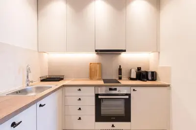 a kitchen with white cabinets and a stove top oven at Luxury Apartments in Plaka by UPSTREET in Athens