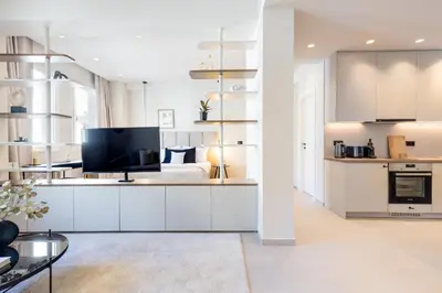 a white living room with a bed and a television at Luxury Apartments in Plaka by UPSTREET in Athens