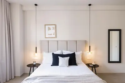 a bedroom with a large white bed with two tables at Luxury Apartments in Plaka by UPSTREET in Athens