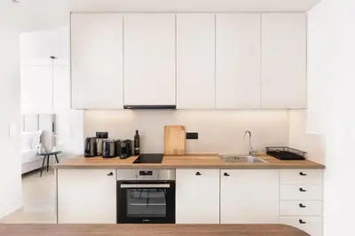 a kitchen with white cabinets and a sink at Luxury Apartments in Plaka by UPSTREET in Athens