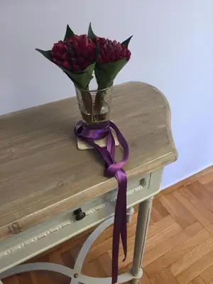 a vase of flowers on a table with a purple ribbon at THE HOUSE OF LAVENDER in Athens
