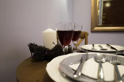 a table with two glasses of wine and a candle at THE HOUSE OF LAVENDER in Athens