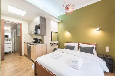 a bedroom with a large bed and a kitchen at Let me Athens you! #3 in Athens