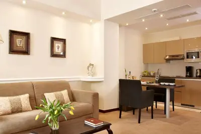 a living room with a couch and a table and a kitchen at Ava Hotel and Suites in Athens