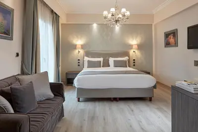 a bedroom with a large bed and a couch at Ava Hotel and Suites in Athens