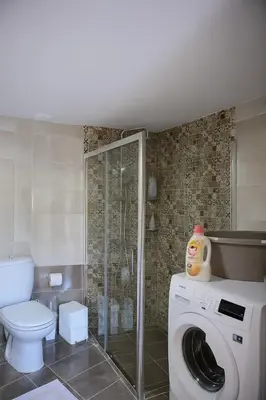 a bathroom with a washing machine and a toilet at Alimos Modern Retreat, near the beach in Athens